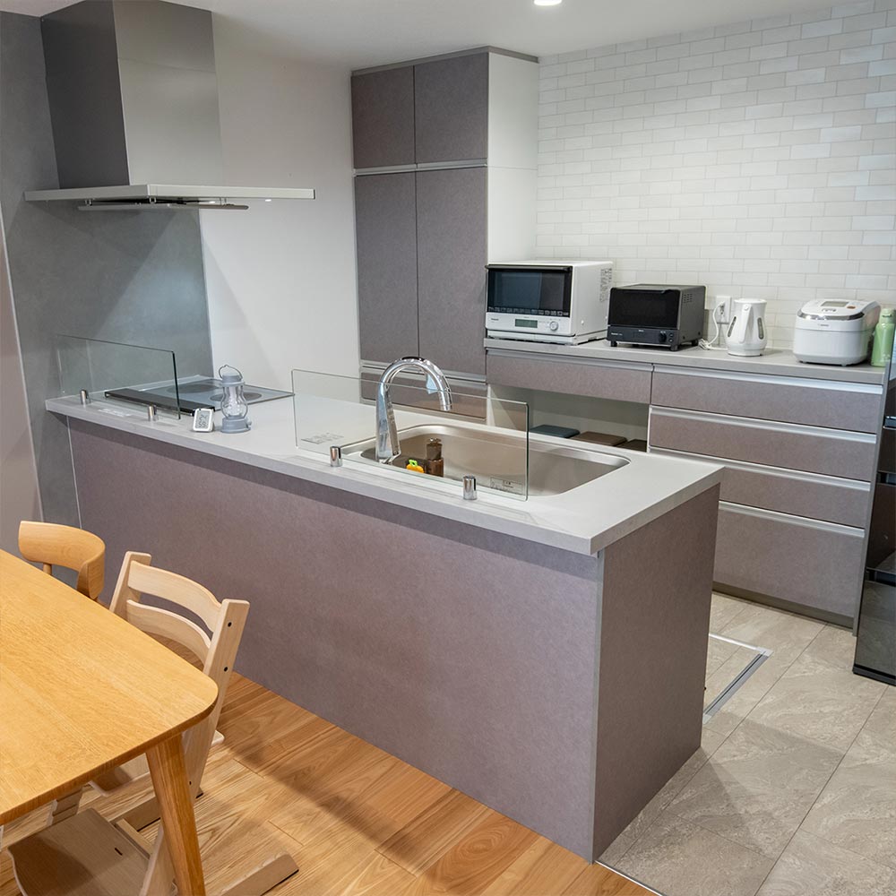イメージ_東京セキスイハイム建築事例_キッチン台とキャビネットの色は、リビングのアクセントクロスと同じグレーを採用