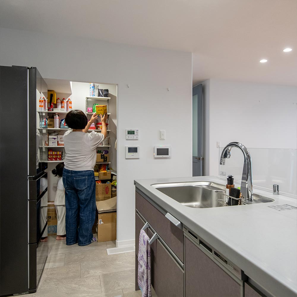 イメージ_東京セキスイハイム建築事例_階段下空間を活用したパントリー。造り付けの可動棚でサイズの異なるストック品もスッキリ収納できます