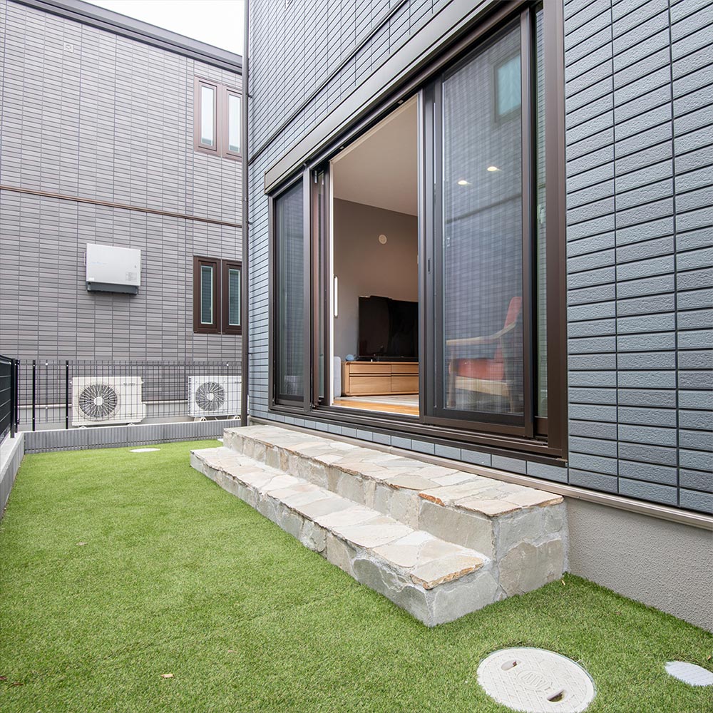 イメージ_東京セキスイハイム建築事例_お手入れが簡単な人工芝に、自然石貼りのステップを組み合わせた庭